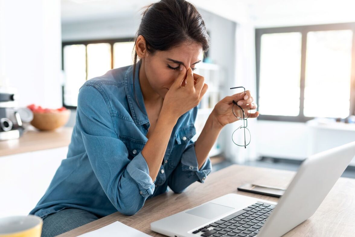 A woman looking stressed at her computer